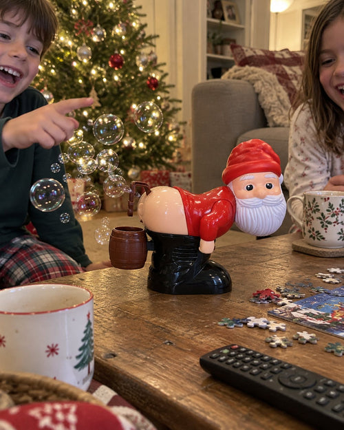 Cheeky Santa blowing bubbles on a coffee table by the tree