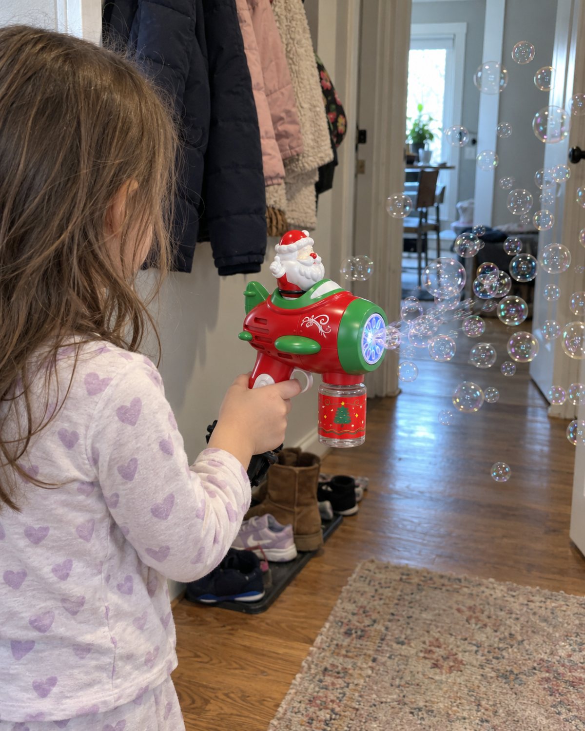 Child holding the Santa Bubble Gun with bubbles in a hallway